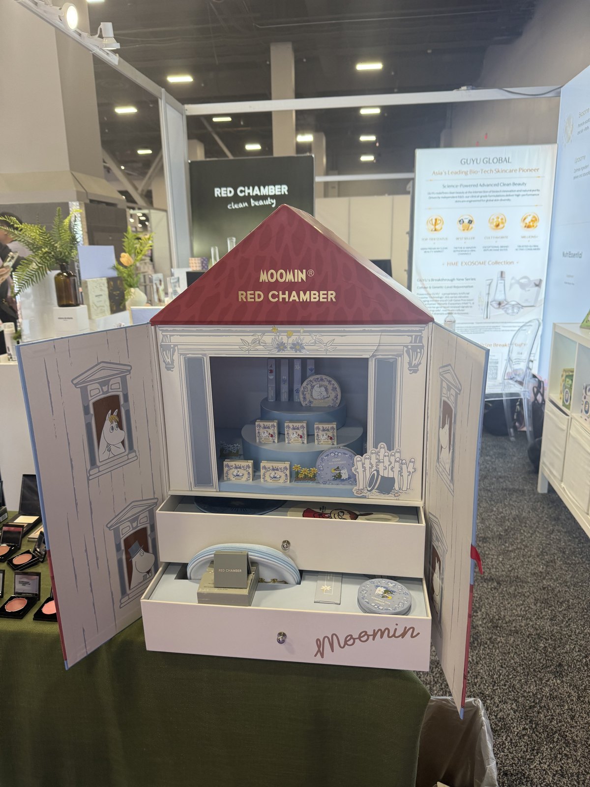 A house-shaped licensed beauty gift set with opening doors and drawers on a trade show table