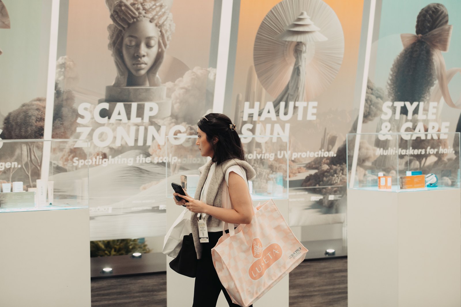 A visitor walking past the Haute Sun and Scalp Zoning displays at the CosmoTrends showcase