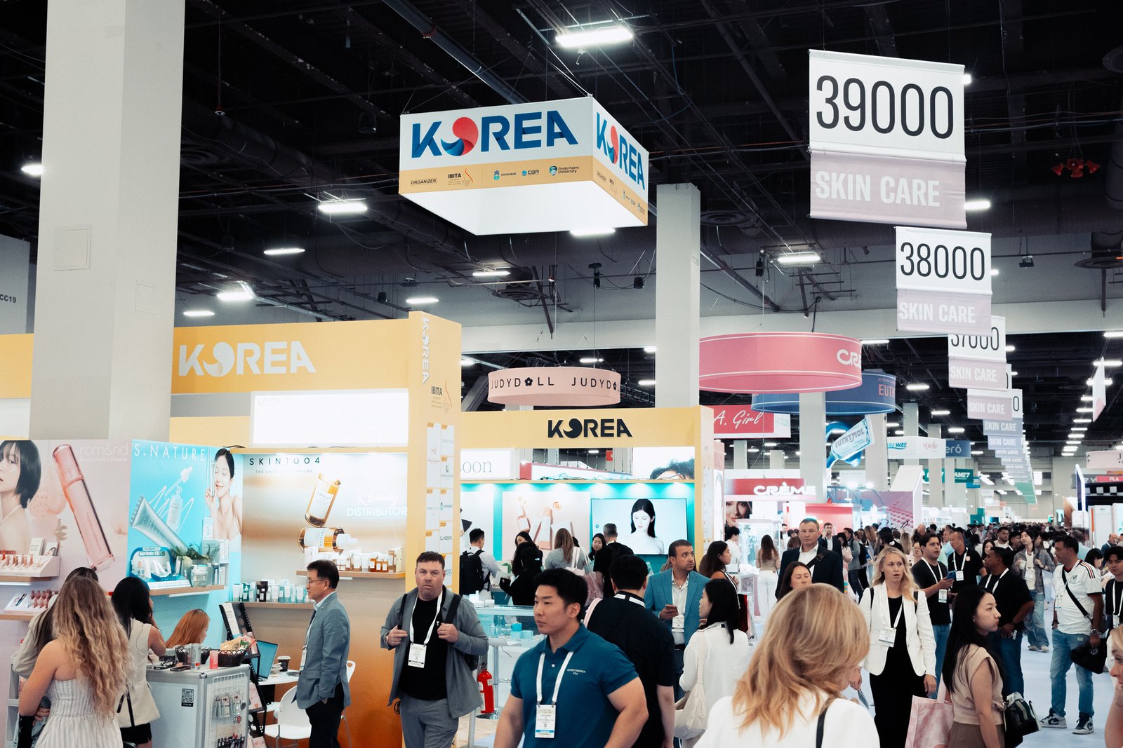 Crowded aisles beneath the Korea pavilion signage on the Cosmoprof North America show floor