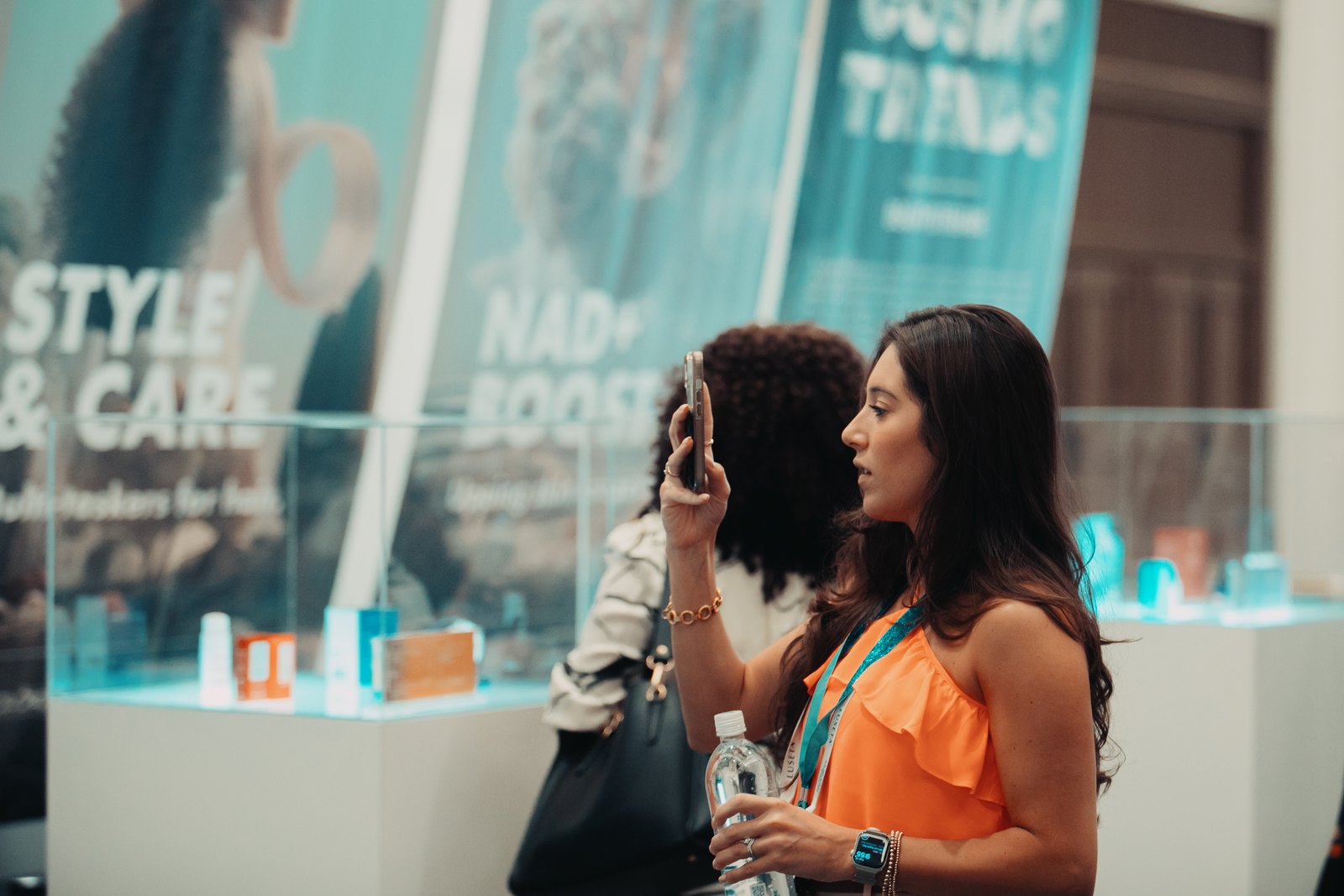 A visitor photographing the Style and Care display case at the CosmoTrends showcase