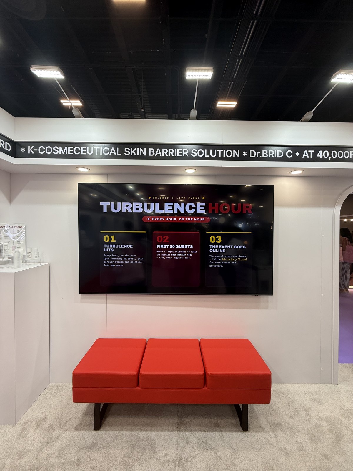 A screen at the stand announcing Turbulence Hour, an hourly activation for the first fifty guests
